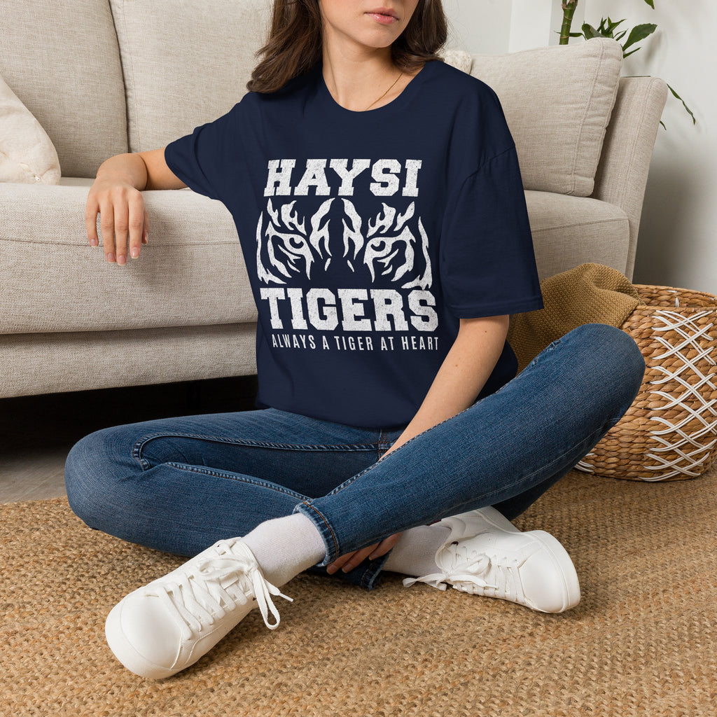 A woman wearing a navy blue graphic T-shirt with white text reading 'HAYSI TIGERS' and a tiger illustration, paired with blue jeans and white sneakers.