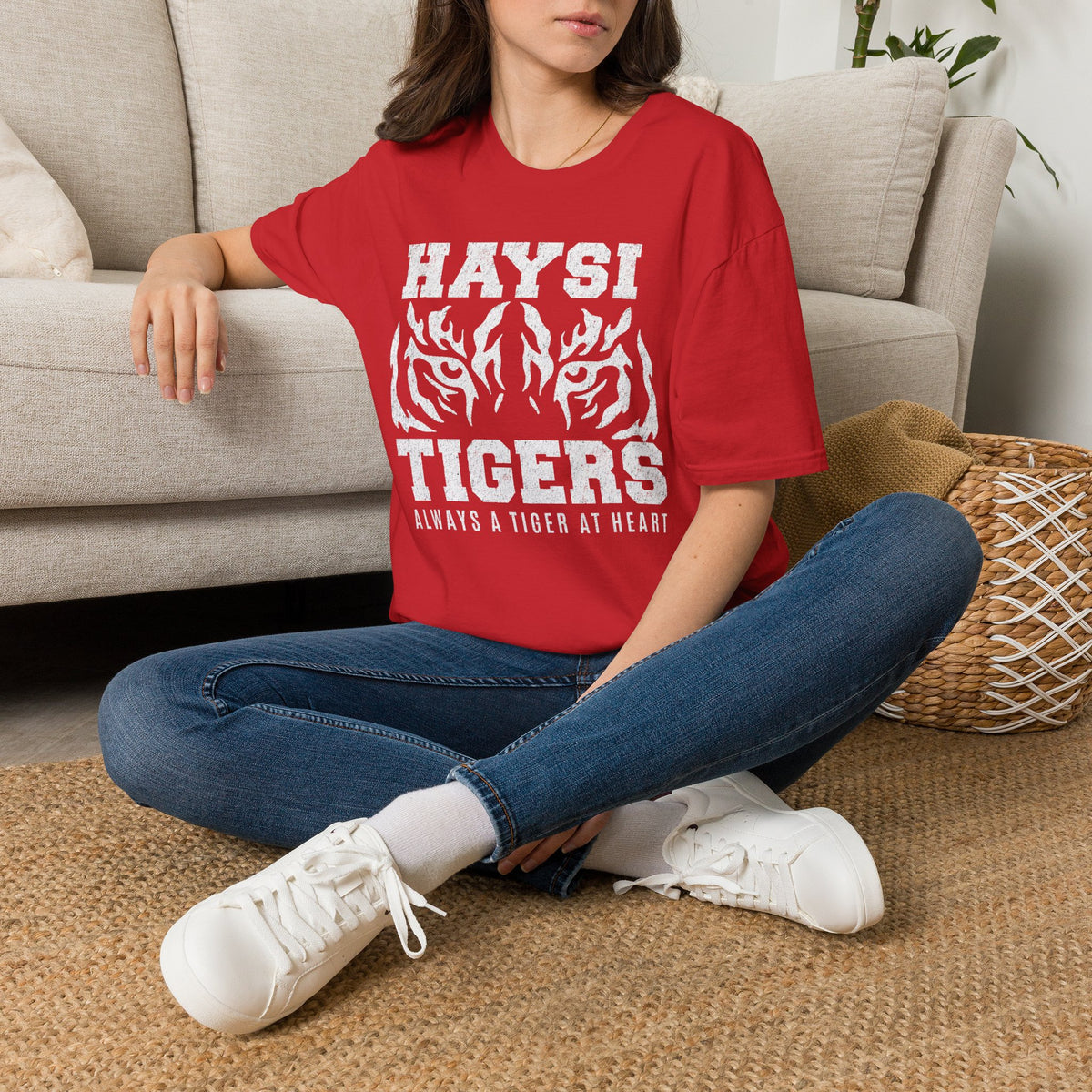 A woman wearing a red graphic T-shirt with white text reading 'HAYSI TIGERS' and a tiger illustration