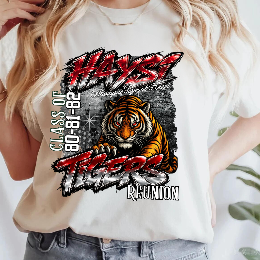 A woman wearing a white graphic t-shirt featuring a tiger and the text 'HAYST TIGERS Class of 80-82 Reunion'.