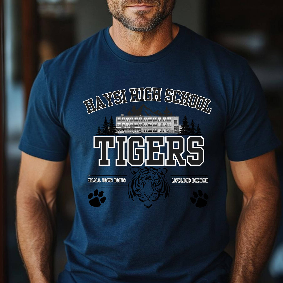A man wearing a navy blue t-shirt with a 'Haysi High School Tigers' graphic on the front, featuring a school bus, tiger head, and paw prints.